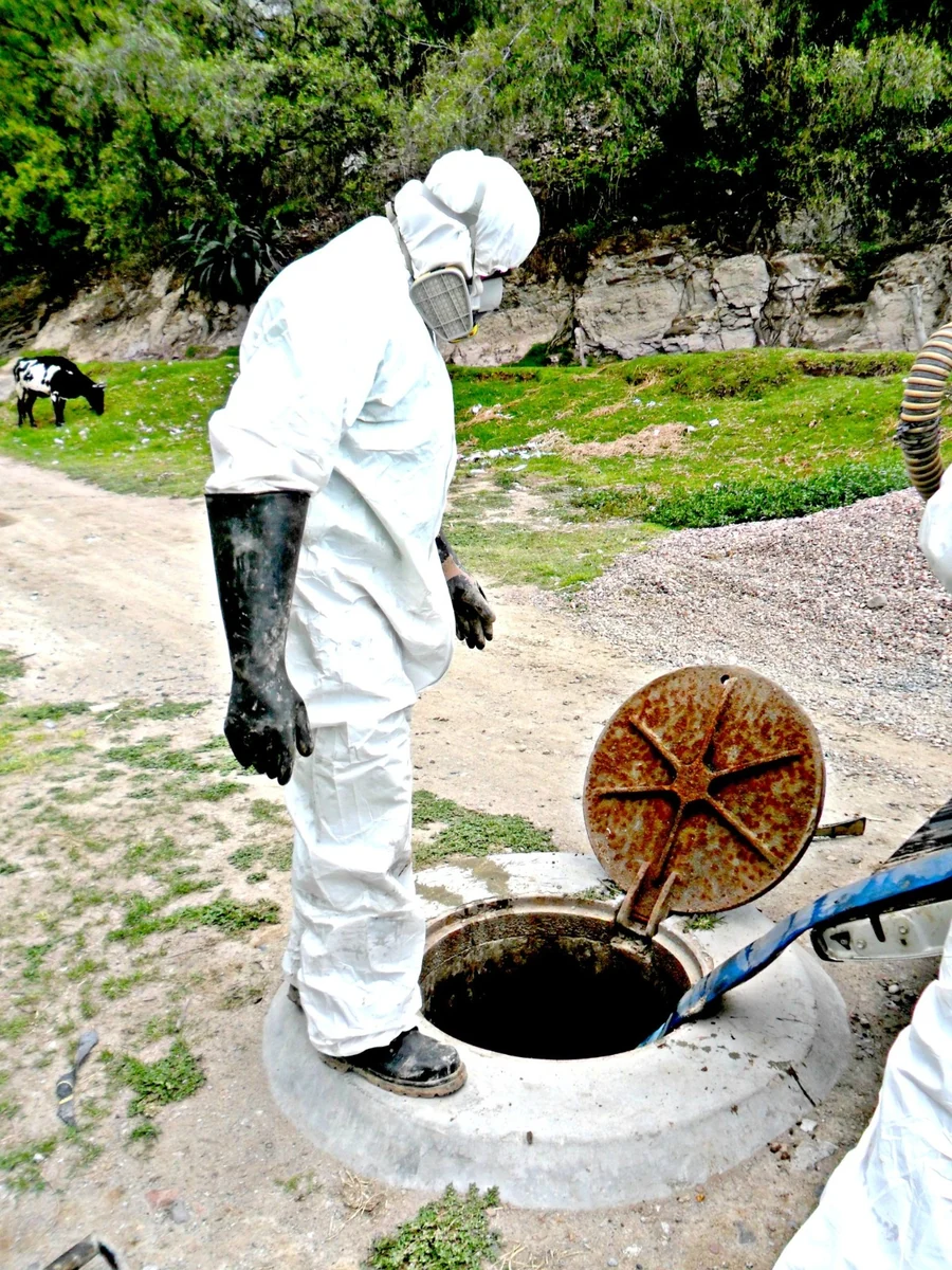 Personal con equipo de protección realizando saneamiento